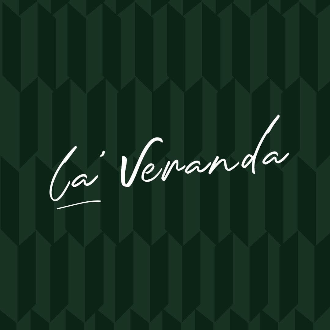 Cocktail glass and the La' Veranda logo glimpsed through a velvet curtain